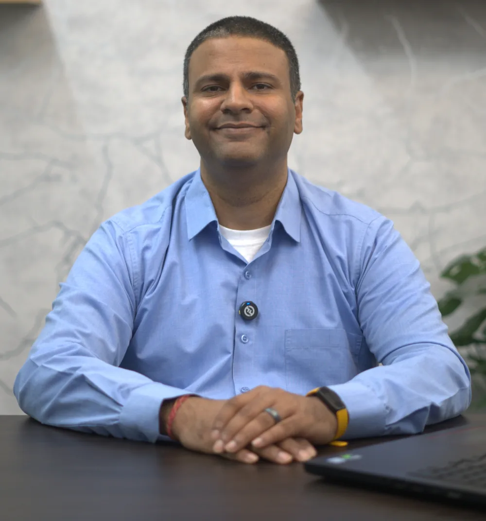 DJ Bhola, CPA, owner of a dental-only CPA firm that provides bookkeeping for dentists, seated at his desk